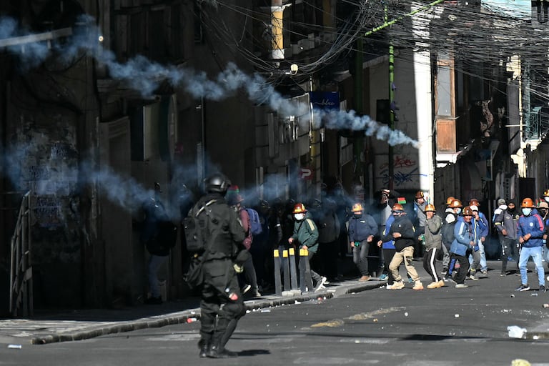 Un agente antidisturbios lanza gases lacrimógenos contra mineros durante una marcha para exigir la renuncia del presidente boliviano Rodrigo Paz, en La Paz, el 14 de mayo de 2026. Durante las últimas dos semanas, trabajadores, campesinos, maestros, grupos indígenas y trabajadores del transporte han estado presionando al gobierno. Sus demandas van desde aumentos salariales y estabilización económica hasta la oposición a la privatización de empresas públicas.