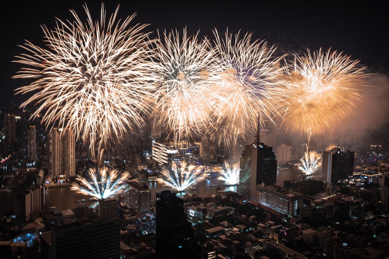 Fireworks light up the midnight sky over the Chao Phraya River during 2026 New Year's Day celebrations in Bangkok on January 1, 2026. (Photo by Chanakarn Laosarakham / AFP)