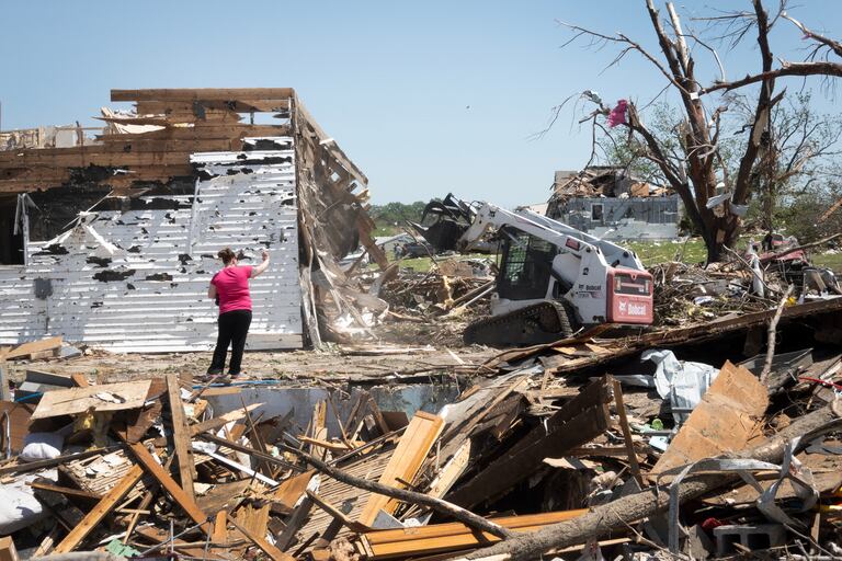 Victoria Turner junto a los restos de su casa, que fue levantada de sus cimientos y movida unos 30 pies mientras se refugiaba en el sótano durante el destructivo tornado del martes 23 de mayo de 2024 en Greenfield, Iowa.