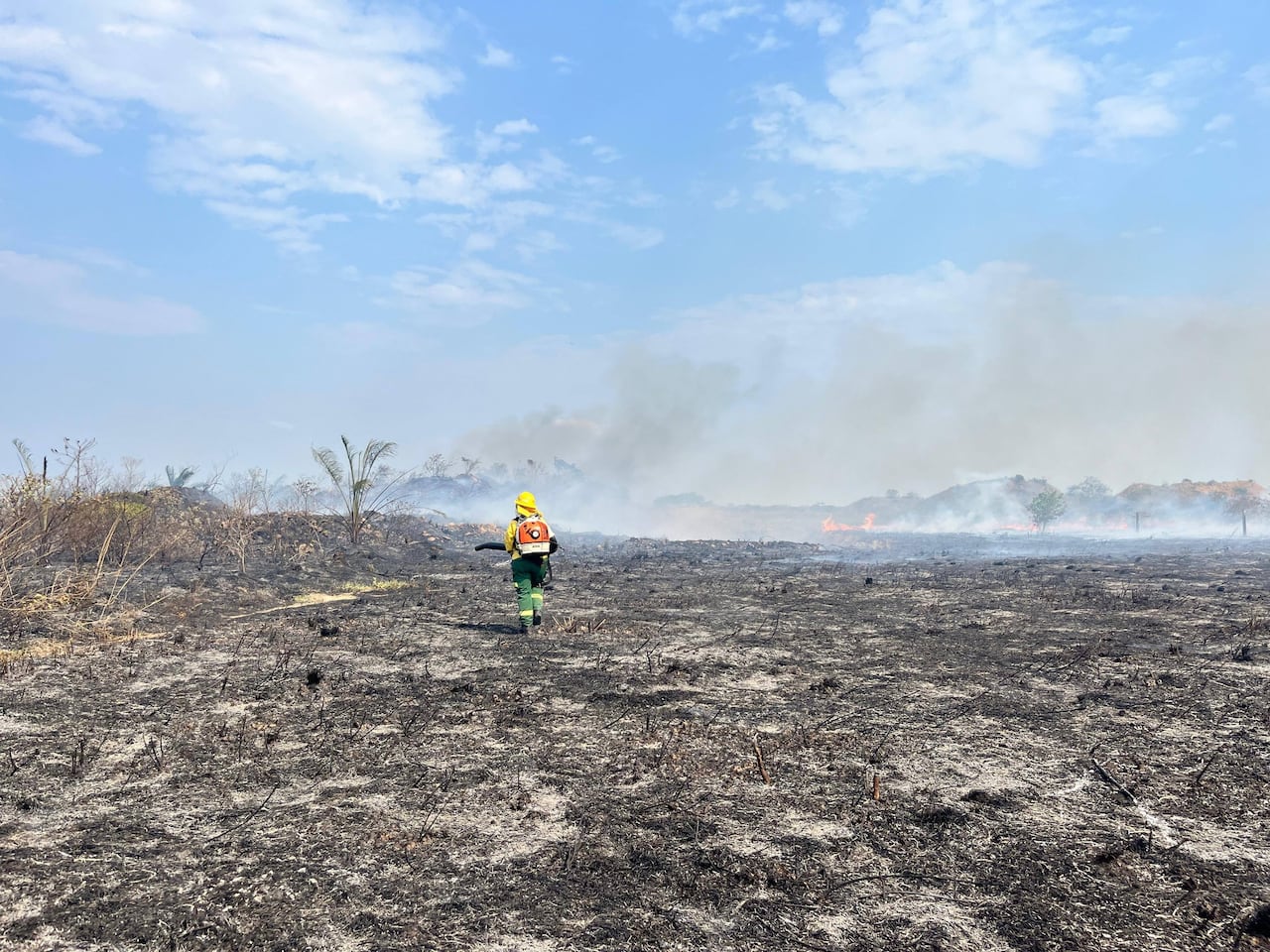 Habitantes del sector colaboran en la atención de la emergencia aportando baldes de agua para ayudar a sofocar el fuego.