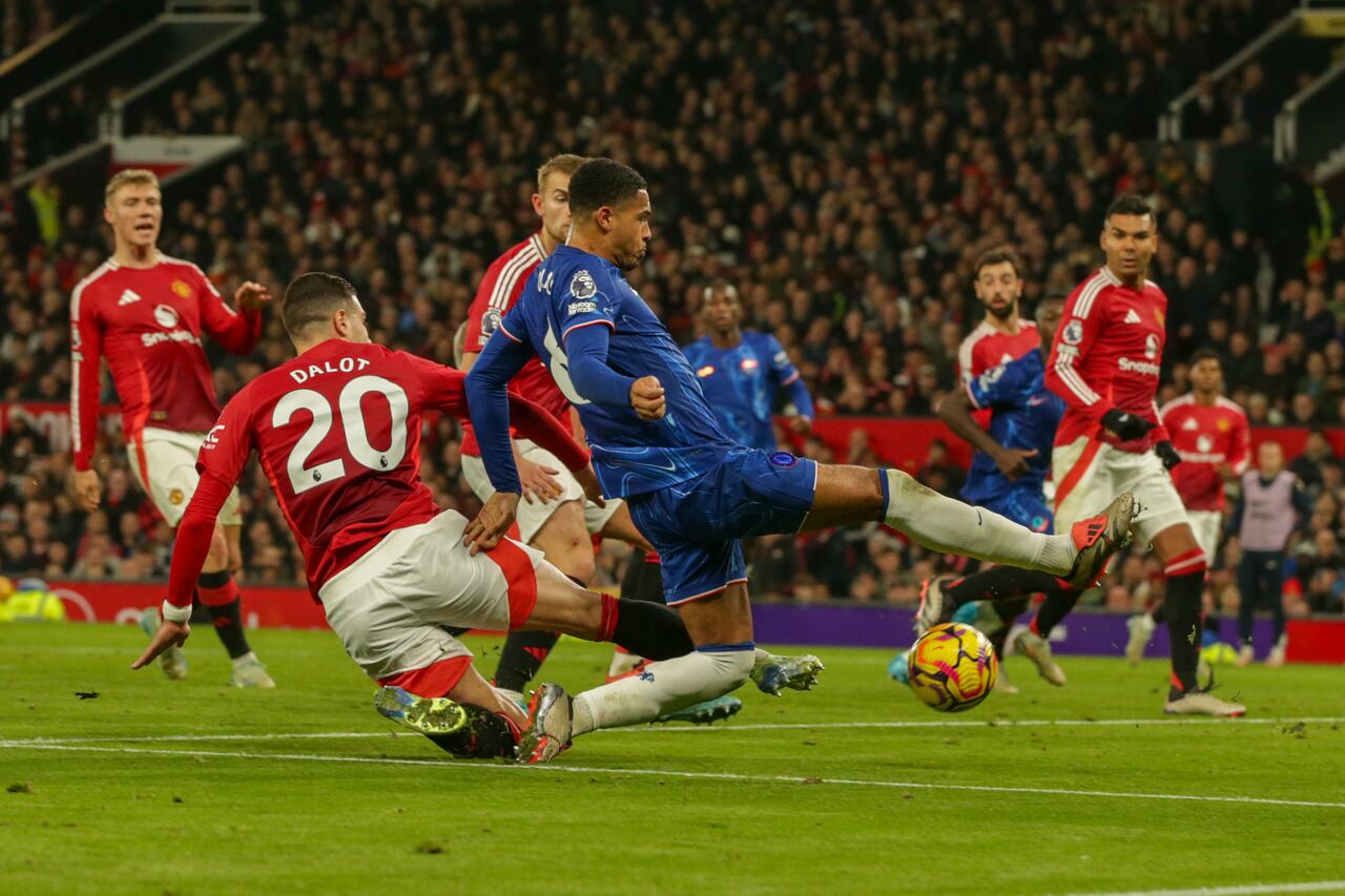 Levi Colwill del Chelsea es tackleado por Diogo Dalot del Manchester United durante el partido de fútbol de la Premier League entre Manchester United y Chelsea en el estadio Old Trafford en Manchester, Inglaterra, el domingo 3 de noviembre de 2024. (Foto AP/Ian Hodgson)