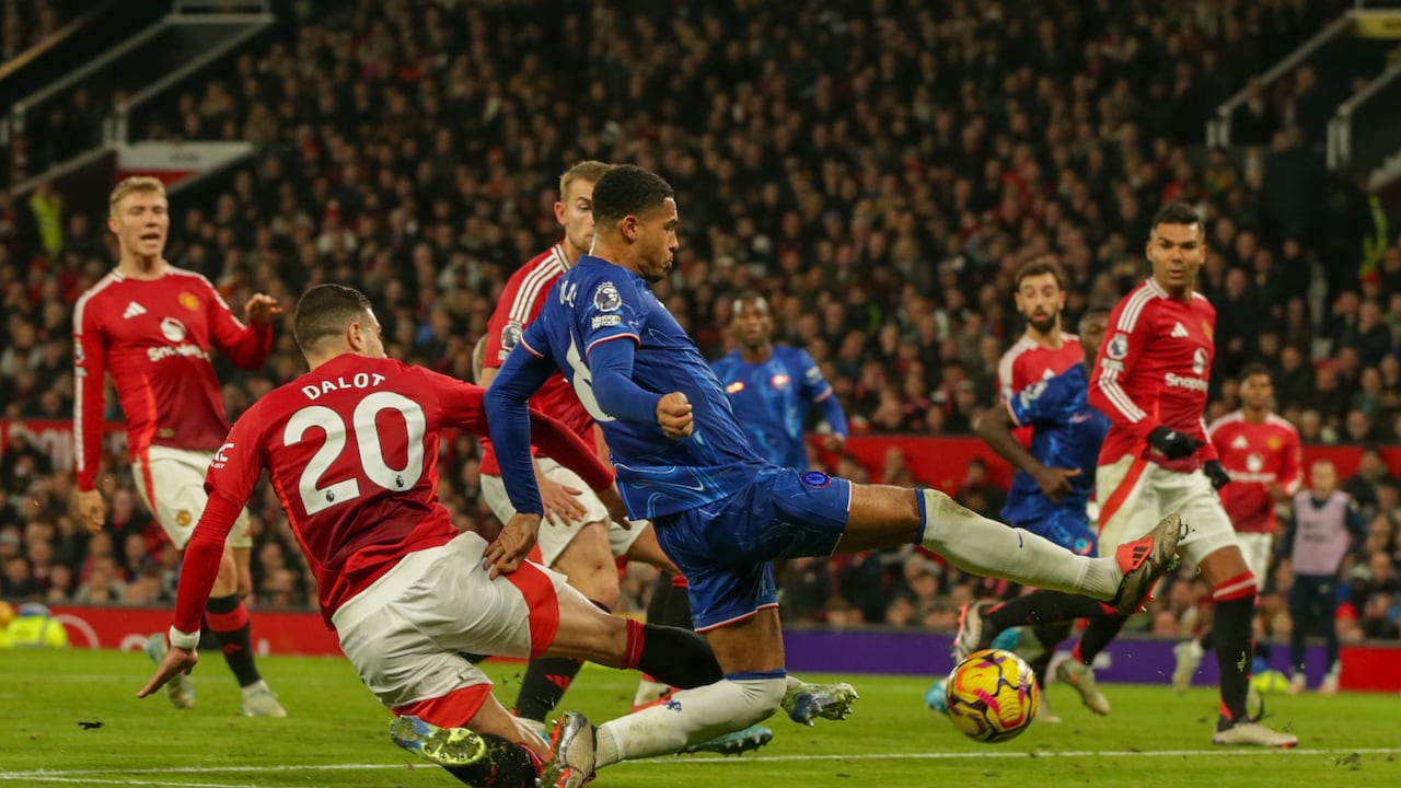 Levi Colwill del Chelsea es tackleado por Diogo Dalot del Manchester United durante el partido de fútbol de la Premier League entre Manchester United y Chelsea en el estadio Old Trafford en Manchester, Inglaterra, el domingo 3 de noviembre de 2024. (Foto AP/Ian Hodgson)