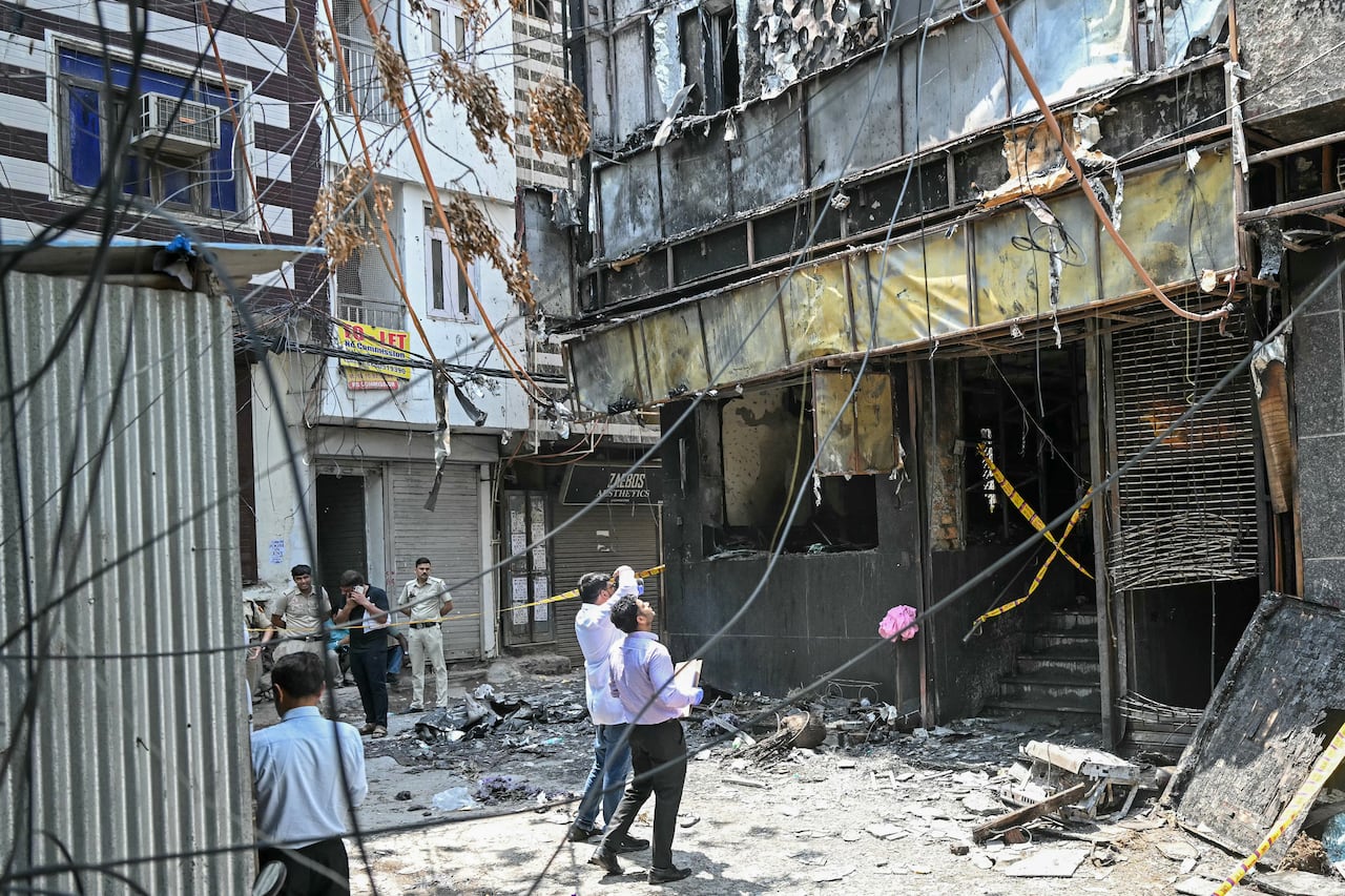 Miembros del equipo forense inspeccionan el lugar tras el incendio que se produjo en un hotel de Nueva Delhi el 3 de junio de 2026.