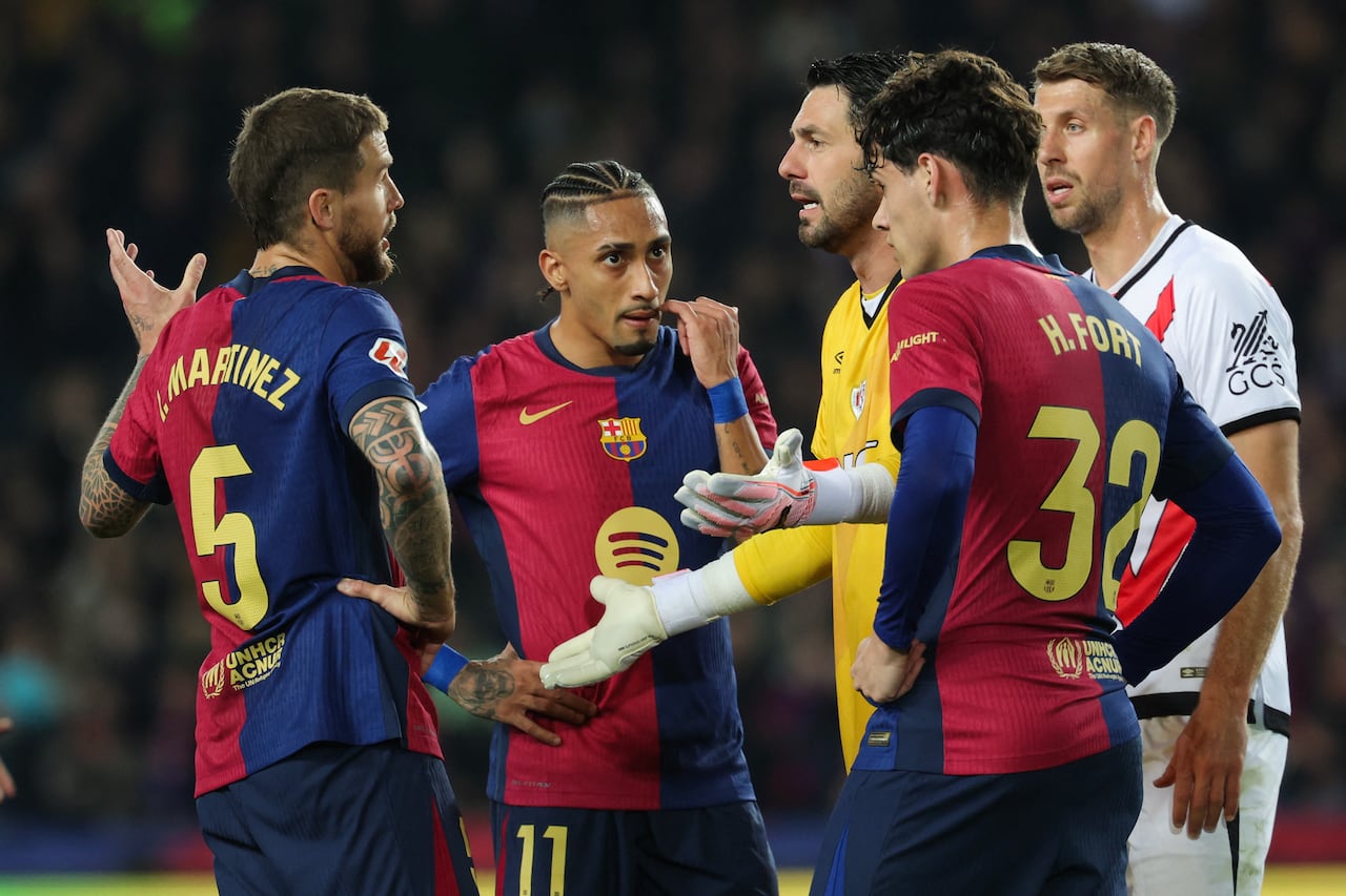Rayo Vallecano's Argentininan goalkeeper #13 Augusto Batalla (C) talks to Barcelona's Spanish defender #05 Inigo Martinez Berridi (L)during the Spanish league football match between FC Barcelona and Rayo Vallecano de Madrid at the Estadi Olimpic Lluis Companys in Barcelona on February 17, 2025. (Photo by LLUIS GENE / AFP)