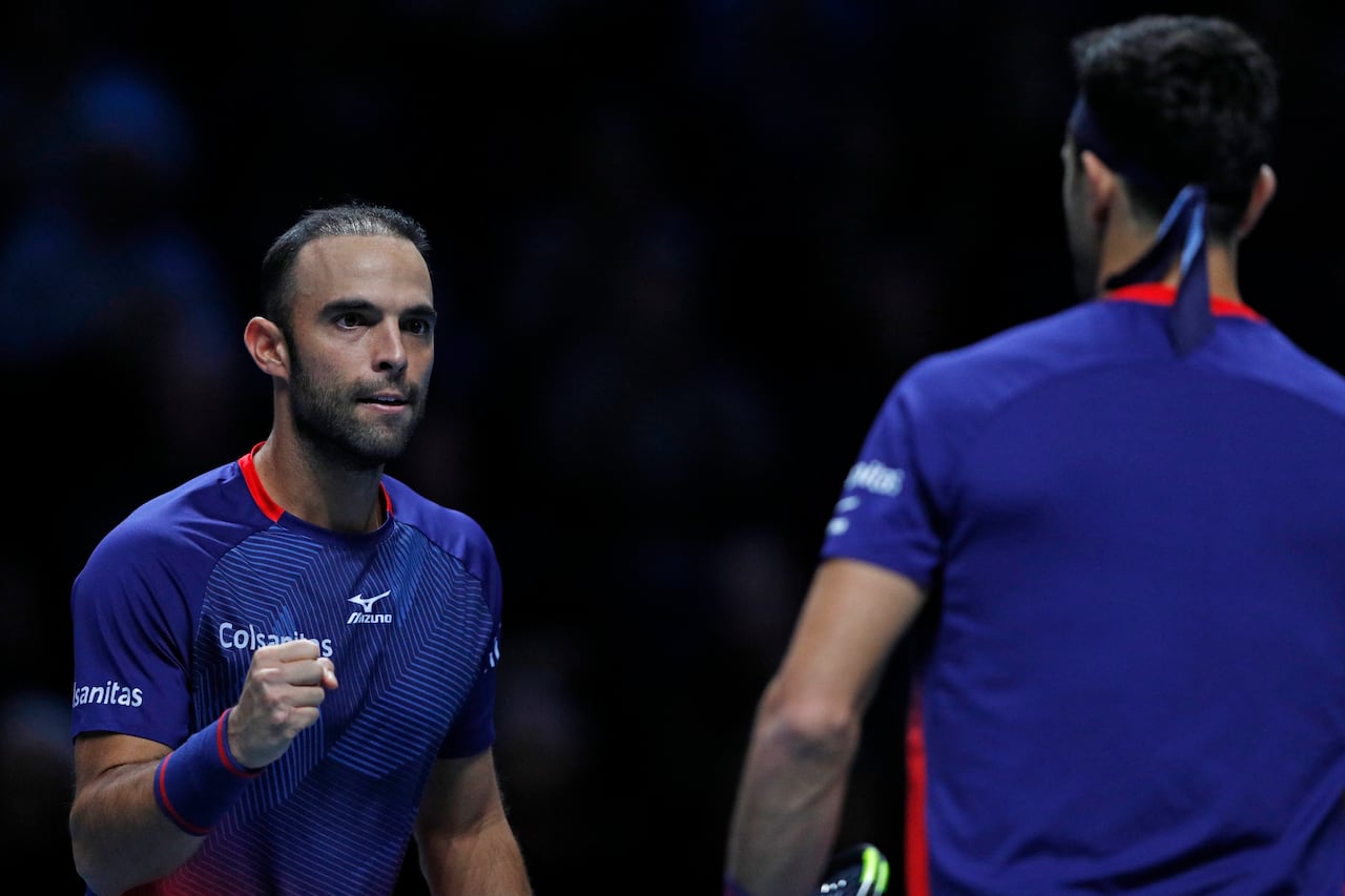 Los colombianos Robert Farah (der.) y Juan Sebastián Cabal (izq.) reaccionan entre puntos contra el holandés Jean-Julien Rojer y el rumano Horia Tecau durante su partido de dobles masculino en el cuarto día del torneo de tenis ATP World Tour Finals en el O2 Arena en Londres el 13 de noviembre de 2019. (Foto de Adrian DENNIS / AFP)