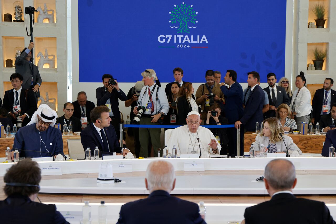 Pope Francis (C) flanked by United Arab Emirates� President Sheikh Mohamed bin Zayed Al Nahyan (L), French President Emmanuel Macron (2nd L) and Italy's Prime Minister Giorgia Meloni (R), and US President Joe Biden (bottom, back turned) take part in a working session on Artificial Intelligence (AI), Energy, Africa-Mediterranean at the Borgo Egnazia resort during the G7 Summit in Savelletri near Bari, Italy, on June 14, 2024. (Photo by Ludovic MARIN / AFP)