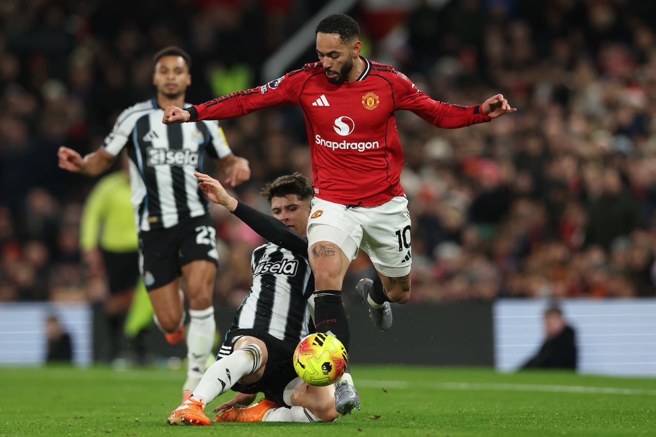 El centrocampista inglés del Newcastle United, Lewis Miley (izq.), compite con el delantero brasileño del Manchester United, Matheus Cunha (der.), durante el partido de la Premier League inglesa entre el Manchester United y el Newcastle United en Old Trafford, en Manchester, noroeste de Inglaterra, el 26 de diciembre de 2025. (Foto de Darren Staples / AFP)