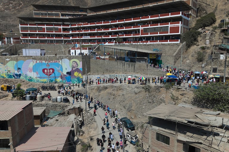 Los votantes hacen fila afuera de un colegio electoral durante las elecciones generales en Lima, Perú.