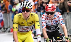 UAE Team Emirates - XRG team's Slovenian rider Tadej Pogacar wearing the overall leader's yellow jersey and Team Visma - Lease a bike team's Danish rider Jonas Vingegaard wearing the best climber's polka dot (dotted) jersey cycle in the final ascent of La Plagne during the 19th stage of the 112th edition of the Tour de France cycling race, 93.1 km between Albertville and La Plagne, in the French Alps, on July 25, 2025. The 19th stage of the Tour de France was shorted from its initial 129.9 km route, bypassing the Col des Saisies where an outbreak of nodular dermatitis in a herd of cattle was discovered, prompting organizers to modify the race route. (Photo by Anne-Christine POUJOULAT / AFP)