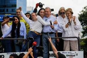Opposition leader Maria Corina Machado, left, embraces opposition candidate Edmundo Gonzalez atop a truck during a rally to protest the official presidential election results declaring President Nicolas Maduro the winner in Caracas, Venezuela, Tuesday, July 30, 2024, two days after the vote. (AP Photo/Cristian Hernandez)