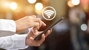 Mano de hombre usando teléfono inteligente móvil con icono wifi. Idea para la red social de comunicación empresarial.