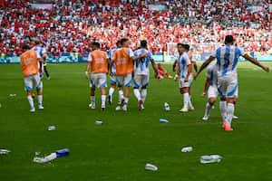 El delantero argentino Giuliano Simeone, observa cómo las botellas de agua arrojadas por los fanáticos de Marruecos ensucian el campo de juego, después de que Argentina anotara su segundo gol, que luego fue anulado en una polémica decisión. (Photo by Arnaud FINISTRE / AFP)