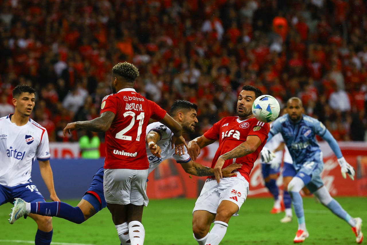 El defensor de Nacional #13 Emiliano Ancheta lucha por el balón con el delantero de Internacional #21 Wesley y el mediocampista de Internacional #08 Bruno Henrique durante el partido de fútbol de la fase de grupos de la Copa Libertadores entre el Internacional de Brasil y el Nacional de Uruguay en el estadio Beira Rio en Porto Alegre, Brasil, el 22 de abril de 2025. (Foto de SILVIO ÁVILA / AFP)