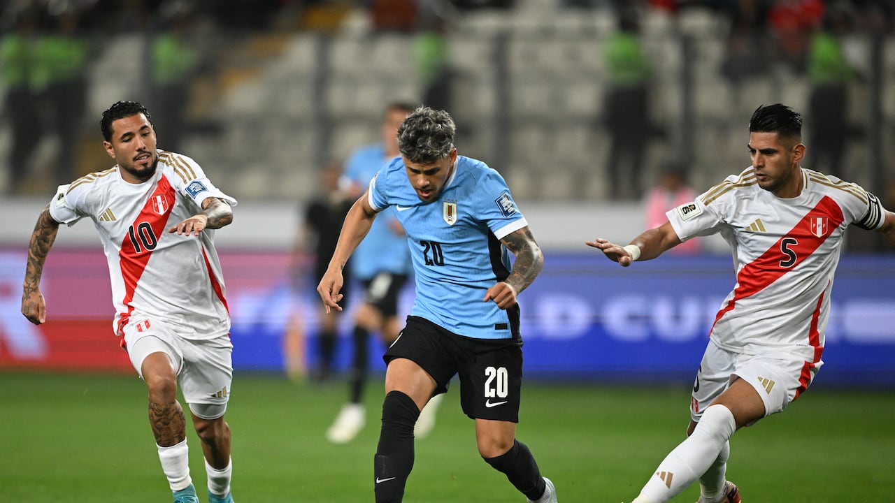 El mediocampista uruguayo #20 Maximiliano Araujo lucha por el balón con el mediocampista peruano #10 Sergio Peña y el defensor #05 Carlos Zambrano durante el partido de fútbol de las eliminatorias sudamericanas de la Copa Mundial de la FIFA 2026 entre Perú y Uruguay en el Estadio Nacional en Lima, el 11 de octubre de 2024. (Foto de ERNESTO BENAVIDES / AFP)