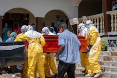 The coffin of a person suspected of having died from Ebola is hoisted onto a pick up truck by health worker at a hospital in Bunia, in the eastern Democratic Republic of the Congo.