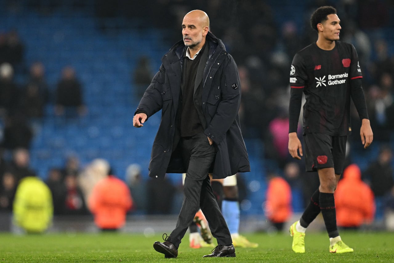 El entrenador español del Manchester City, Pep Guardiola (centro), en el campo tras el partido de la fase de liga de la UEFA Champions League entre el Manchester City y el Bayer Leverkusen en el Etihad Stadium de Mánchester, noroeste de Inglaterra, el 25 de noviembre de 2025. El Leverkusen ganó 2-0. (Foto de Oli SCARFF / AFP)