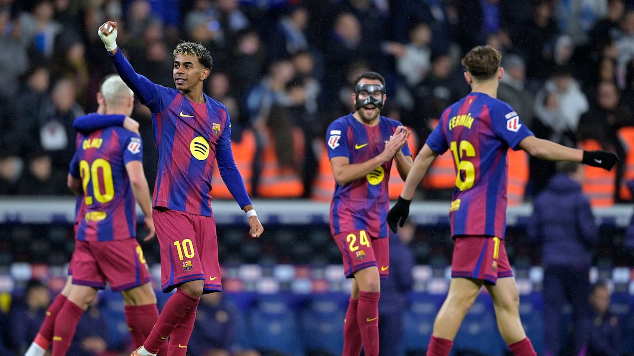 El delantero español #10 del Barcelona, Lamine Yamal, y sus compañeros celebran el segundo gol anotado por el delantero polaco #09 del Barcelona, Robert Lewandowski, durante el partido de la Liga española entre el RCD Espanyol y el FC Barcelona en el Estadio RCDE en Cornella de Llobregat el 3 de enero de 2026. (Foto de MANAURE QUINTERO / AFP)