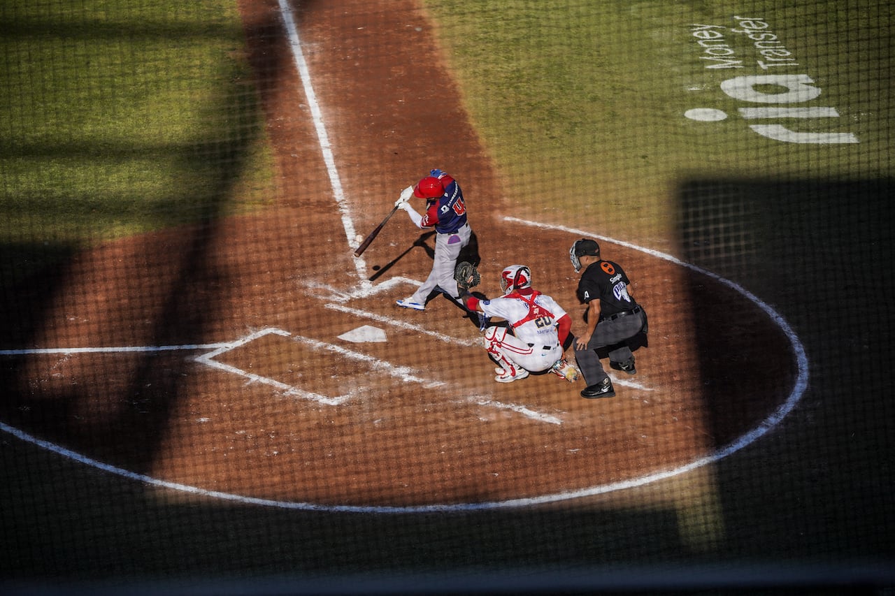 Junior Lake (C), de los Leones del Escogido de República Dominicana, batea la pelota en la primera entrada del partido semifinal del torneo de béisbol de la Serie del Caribe entre República Dominicana y Venezuela en el Estadio El Nido De Los Águilas en Mexicali, Baja California, México, el 5 de febrero de 2025. (Foto de José SÁNCHEZ / AFP)