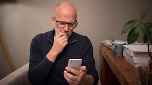 Hombre angustiado revisando su dispositivo móvil (Imagen de referencia)