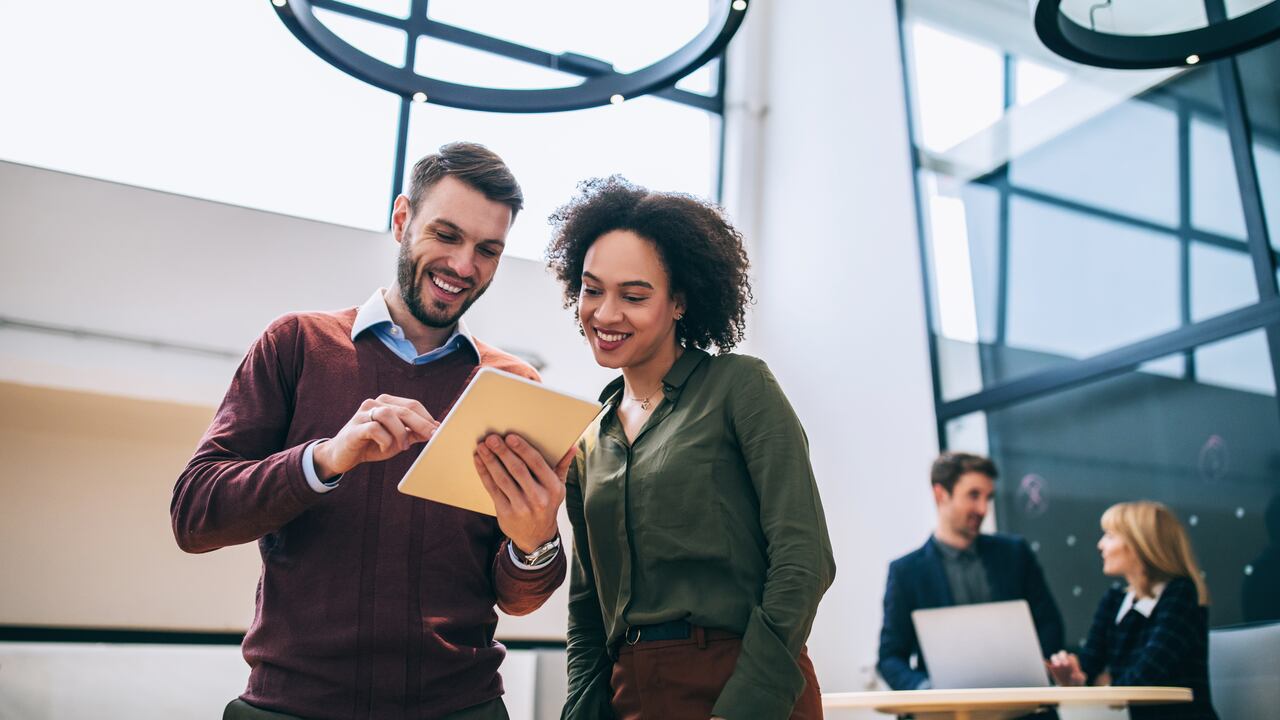 Convertir ideas en realidad. Compañeros de trabajo mirando computador portátil, oficina.