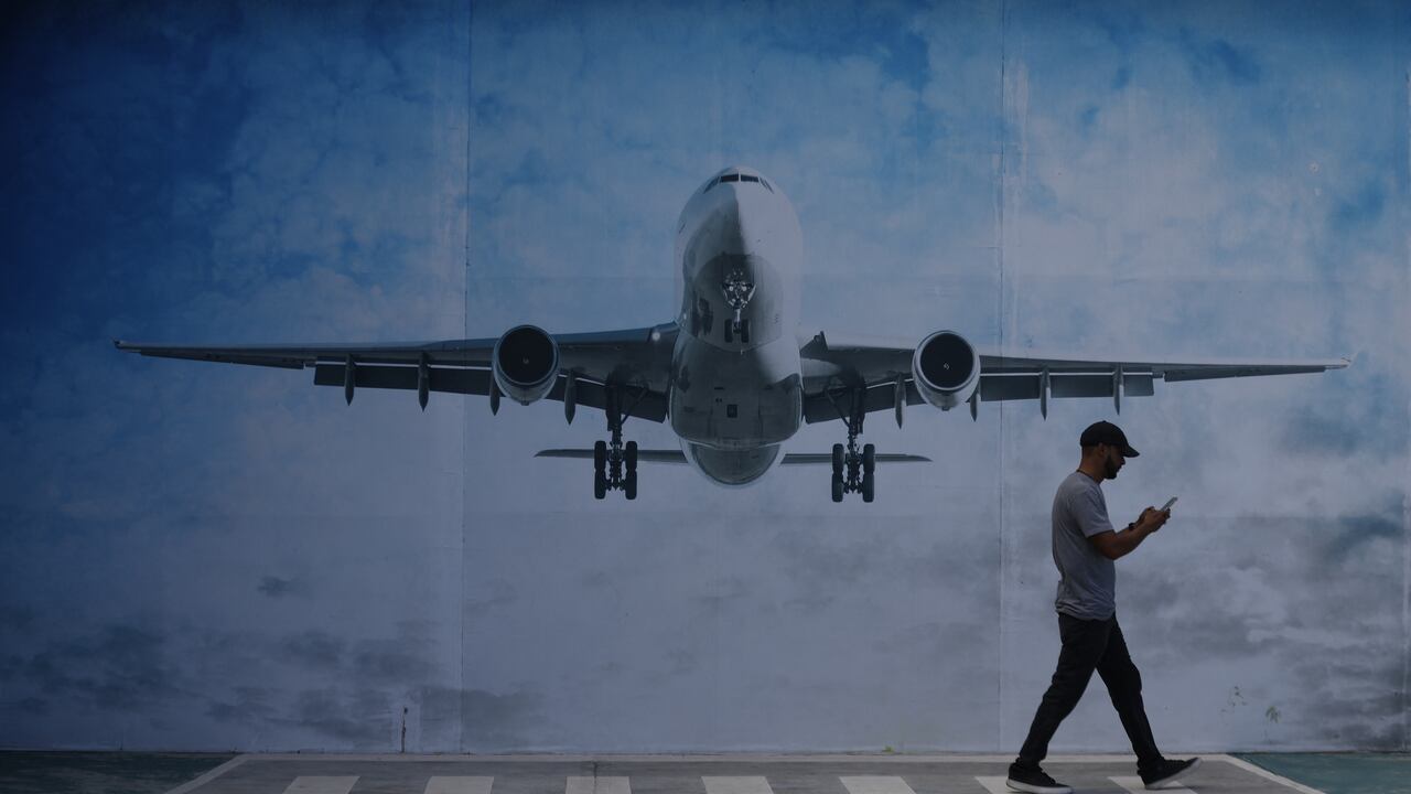 LA GUAIRA, VENEZUELA - NOVEMBER 30: A man walks next to a mural of an airplane in La Guaira State, Venezuela, on November 30, 2025. US President Donald Trump significantly escalated his threats against Venezuela on Saturday with an ominous warning that the country's airspace should be considered “closed,�? raising fears of imminent military action. Pedro Mattey / Anadolu (Photo by Pedro Mattey / Anadolu via AFP)