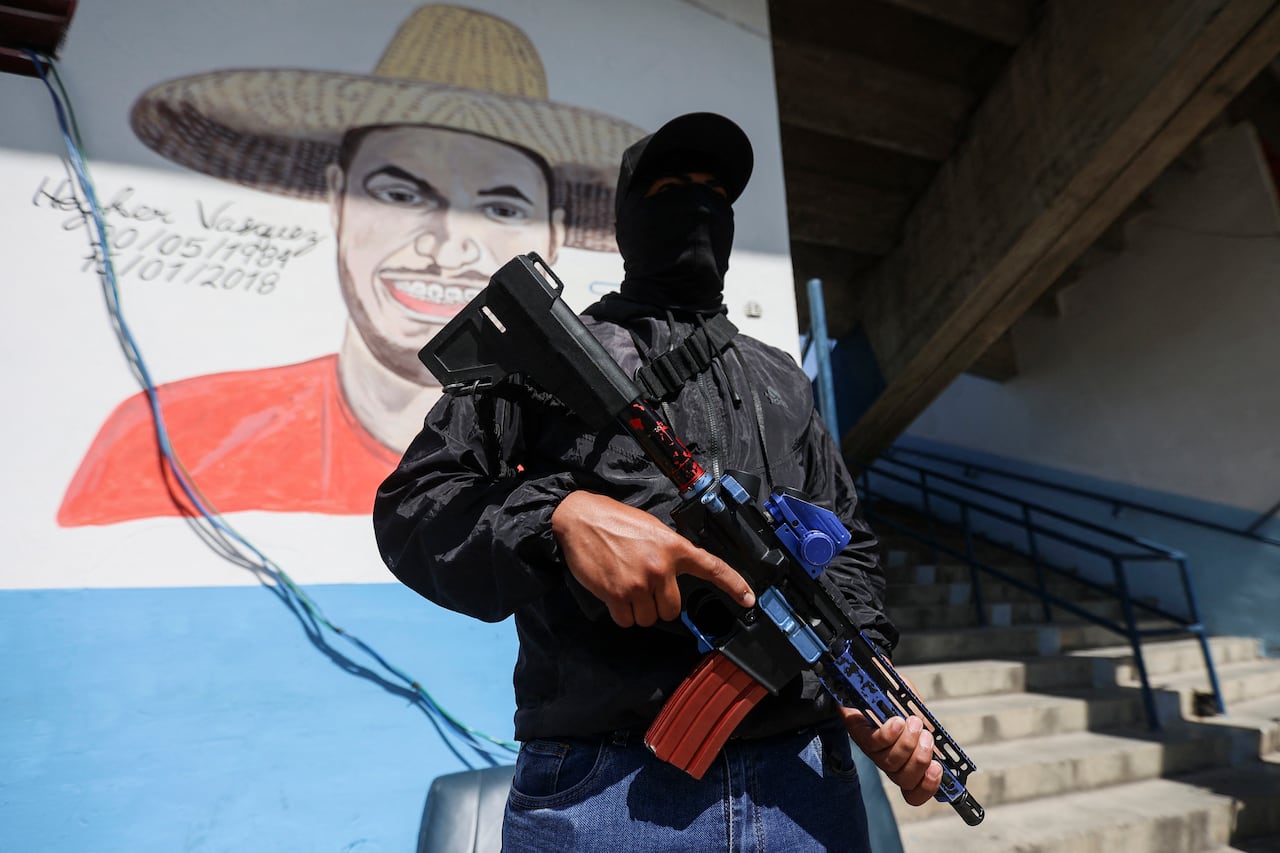 Un miembro de '3 Raíces', un grupo progubernamental conocido como 'Colectivos', monta guardia con un fusil de asalto en la sede de la organización en el barrio obrero 23 de Enero