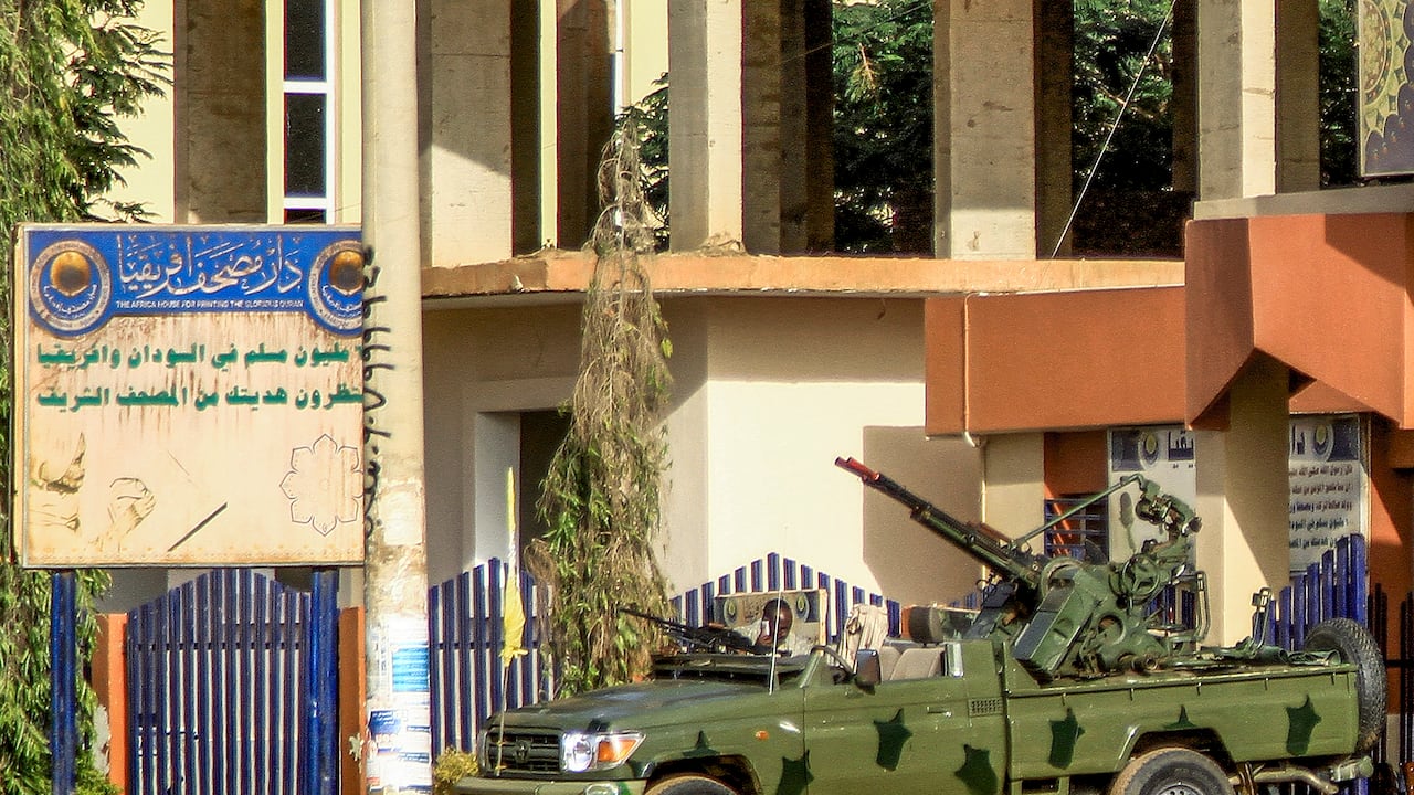 Un vehículo "técnico" (camioneta montada con torreta) de los paramilitares de las Fuerzas de Apoyo Rápido (RSF) de Sudán está estacionado frente a las oficinas de Dar al-Mushaf (Editorial del Sagrado Corán Africano)
