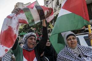 Una mujer palestina levanta un cuerpo simulado de un niño palestino muerto envuelto en una manta manchada de sangre durante una manifestación en apoyo a la Franja de Gaza. Foto: Marwan Naamani/dpa (Foto de Marwan Naamani/Picture Alliance vía Getty Images)