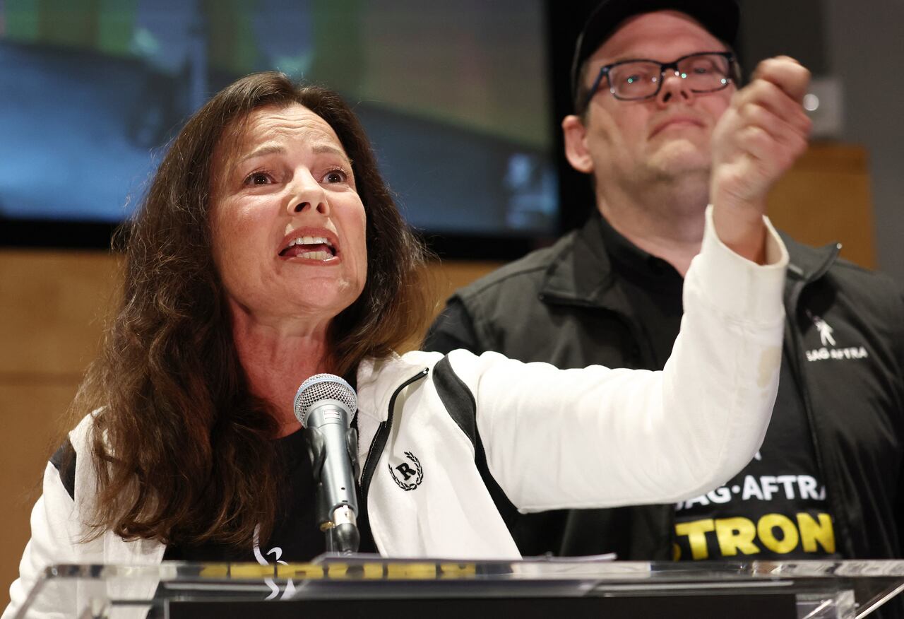 LOS ANGELES, CALIFORNIA - JULY 13: SAG-AFTRA President Fran Drescher speaks as SAG-AFTRA National Executive Director Duncan Crabtree-Ireland looks on at a press conference announcing their strike against Hollywood studios on July 13, 2023 in Los Angeles, California. Members of SAG-AFTRA, Hollywood�s largest union which represents actors and other media professionals, will join striking WGA (Writers Guild of America) workers at midnight in the first joint walkout against the studios since 1960. The strike could shut down Hollywood productions completely with writers in the third month of their strike against the Hollywood studios. Mario Tama/Getty Images/AFP (Photo by MARIO TAMA / GETTY IMAGES NORTH AMERICA / Getty Images via AFP)