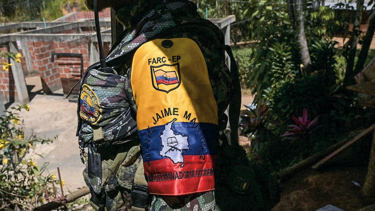 Un guerrillero de la disidencia de las FARC «Jaime Martínez» hace guardia mientras el comandante Andrey concede una entrevista cerca del municipio de Suárez, en el departamento del Cauca, el 30 de agosto de 2023. El grupo disidente EMC, que rechazó el acuerdo de paz de 2016 que condujo al desarme de las FARC, iniciará conversaciones de paz directas con el Gobierno colombiano el 31 de agosto. (Photo by JOAQUIN SARMIENTO / AFP)