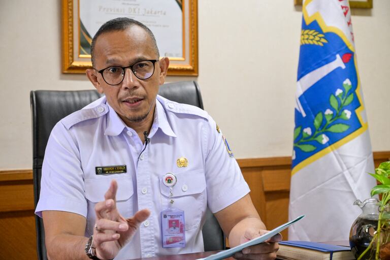 Hasudungan A. Sidabalok, head of Jakarta's food resiliency, maritime and agriculture agency (DKPKP), answers AFP's questions during an interview in Jakarta on November 26, 2025. This week, Jakarta's authorities announced a ban in the capital on trade for the consumption of rabies-transmitting animals, including cats and dogs. The prohibition, with a six-month grace period before enforcement begins, was hailed by animals rights groups who have long lobbied against the trade. (Photo by BAY ISMOYO / AFP) / TO GO WITH 'INDONESIA-ANIMAL-LAW-HEALTH-FOOD-DRINK, REPORTAGE' BY MARCHIO GORBIANO