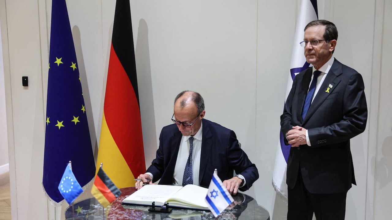 El canciller alemán, Friedrich Merz (izq.), firma el libro de visitas junto al presidente israelí, Isaac Herzog, durante una reunión en la residencia presidencial en Jerusalén el 6 de diciembre de 2025.