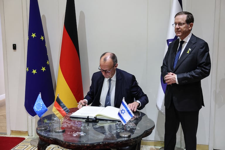 El canciller alemán, Friedrich Merz (izq.), firma el libro de visitas junto al presidente israelí, Isaac Herzog, durante una reunión en la residencia presidencial en Jerusalén el 6 de diciembre de 2025.