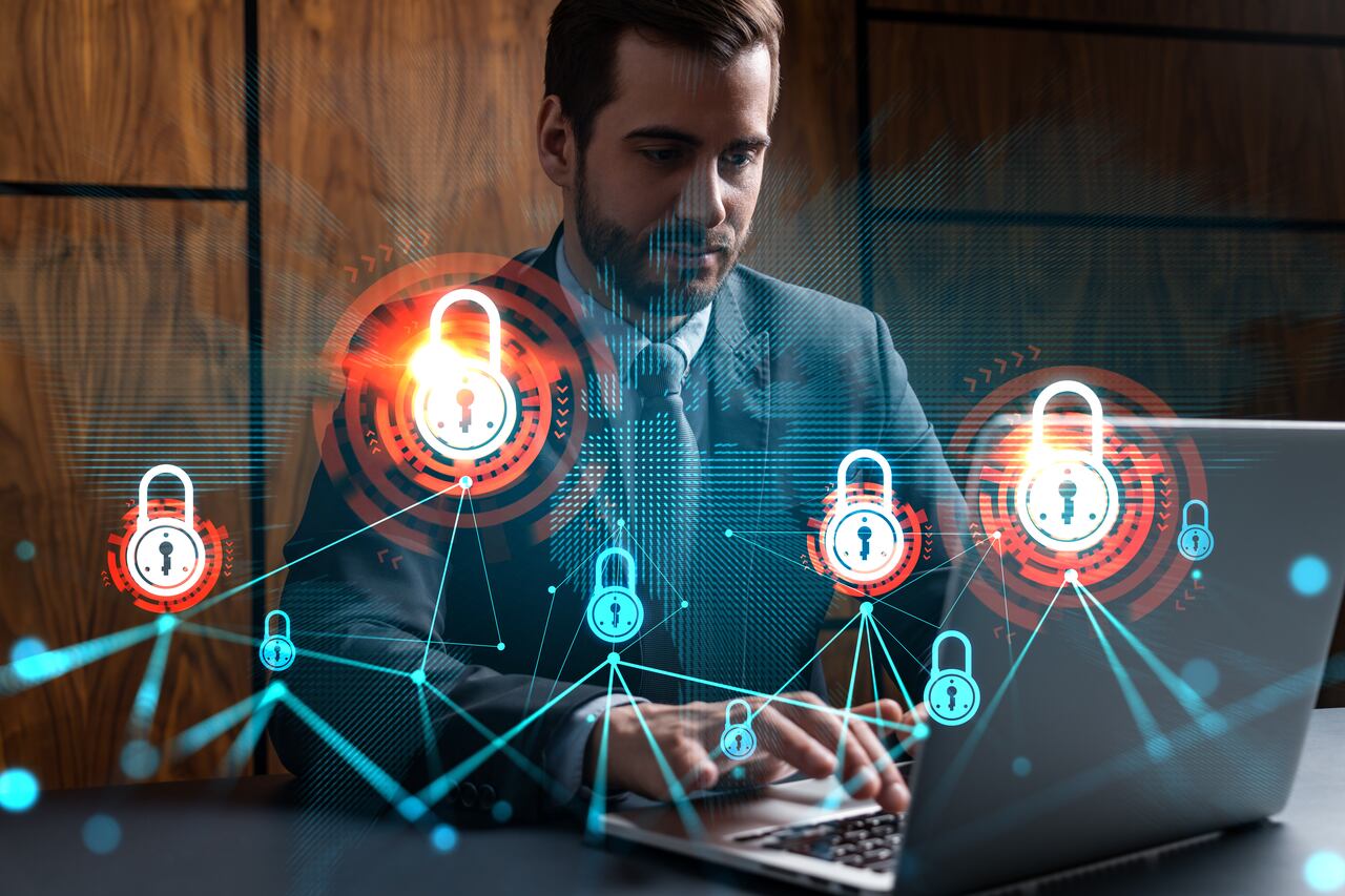 Businessman in office working with laptop, develop data protection system to diminish business risks, typing computer. Double exposure.