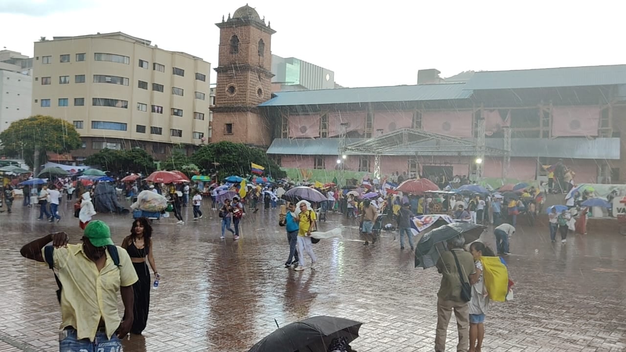 Marchantes en Cali, fueron sorprendidos por un fuerte aguacero este jueves.