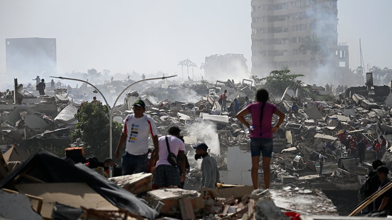 Voluntarios buscan posibles víctimas entre los escombros de un edificio derrumbado tras el doble terremoto que sacudió Caraballeda, estado de La Guaira, a unos 40 km al noreste de Caracas, el 25 de junio de 2026. El número de fallecidos por los sismos, de magnitud 7.2 y 7.5, asciende a al menos 188, con más de 1520 heridos, según informó el diputado Jorge Rodríguez, mientras los residentes continúan la búsqueda de familiares desaparecidos. (Foto de Federico PARRA / AFP)