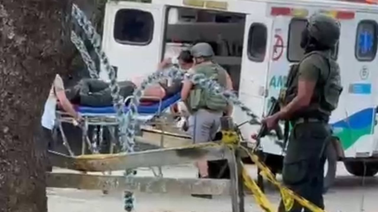 Los policías ayudan a su compañero herido, ayudándolo a subirlo a la ambulancia mientras se defienden del ataque con drones.