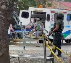 Los policías ayudan a su compañero herido, ayudándolo a subirlo a la ambulancia mientras se defienden del ataque con drones.