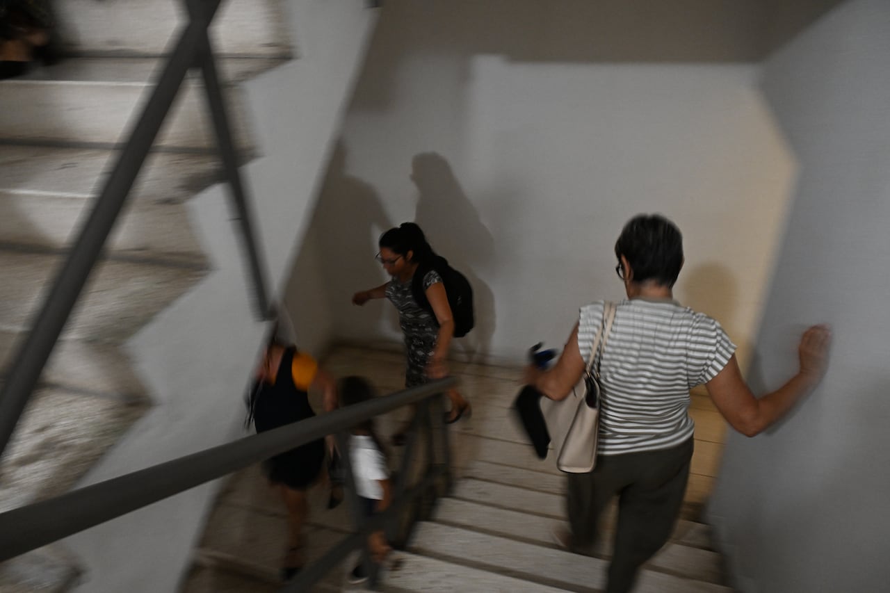 Trabajadores bajan corriendo las escaleras tras un temblor provocado por un terremoto de magnitud 6,5 en La Habana, el 8 de junio de 2026. Un fuerte terremoto sacudió la costa occidental de Cuba el 8 de junio de 2026. Periodistas de la AFP en La Habana informaron de 20 segundos de temblor que obligaron a los cubanos a salir de los edificios a las calles. El Servicio Geológico de Estados Unidos informó que el sismo tuvo una magnitud de 6,1 y se produjo a unos 100 kilómetros (62 millas) de la punta occidental de la isla. (Foto de YAMIL LAGE / AFP)
