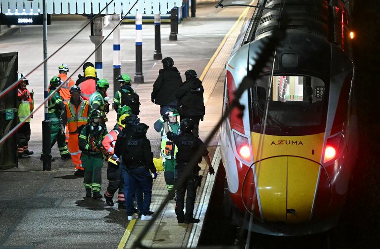 Police officers and members of the Emergency services work alongside an LNER Azuma train at Huntingdon Station in Huntingdon, eastern England, on November 1, 2025, following a stabbing on a train. UK police said they had arrested two suspects Saturday as "a number of people" were taken to hospital after a stabbing on a train in Cambridgeshire, eastern England. "We are currently responding to an incident on a train to Huntingdon where multiple people have been stabbed," British Transport Police said on X, adding that "two people have been arrested". (Photo by JUSTIN TALLIS / AFP)
