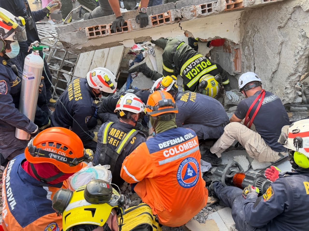 Momento en el equipo de rescate trabaja para encontrar a las personas atrapadas en edificación de Pereira.