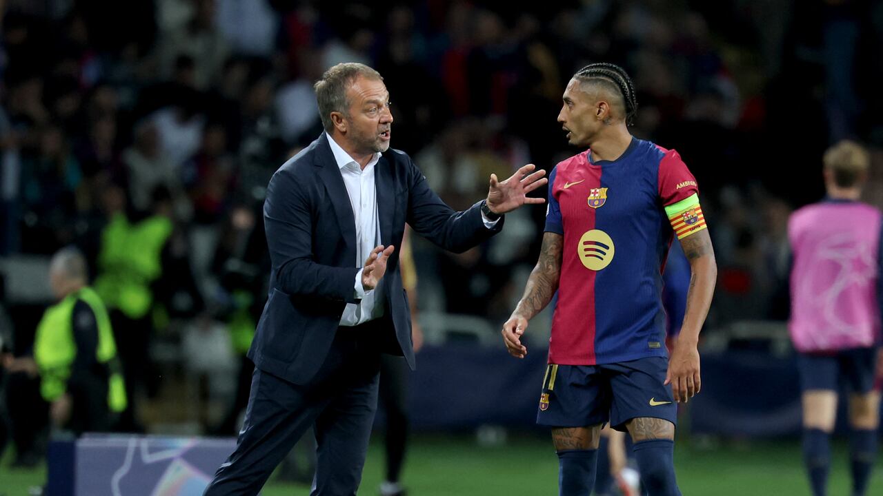 El entrenador alemán de Barcelona, Hans-Dieter Flick, habla con el delantero brasileño de Barcelona #11 Raphinha durante la Liga de Campeones de la UEFA.