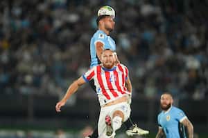 El uruguayo Sebastián Cáceres (arriba) cabecea el balón ante el paraguayo Isidro Pitta durante un partido de clasificación para la Copa Mundial de la FIFA 2026, en Montevideo, Uruguay, el viernes 6 de septiembre de 2024. (Foto AP/Matilde Campodonico)