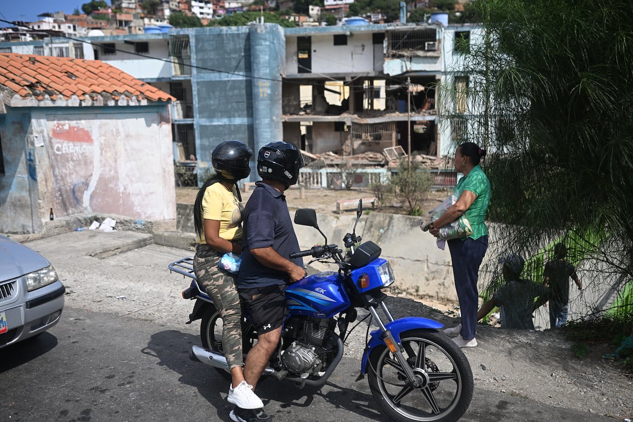 Personas observan un edificio dañado en Catia La Mar, estado de La Guaira, Venezuela, un día después del ataque de Estados Unidos.