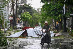 Un hombre conduce una motoneta entre los escombros de una calle después de que el supertifón Yagi azotara Hai Phong el 7 de septiembre de 2024.