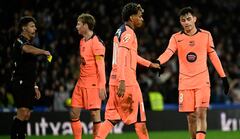 El centrocampista español #08 del Barcelona, Pedri, y el delantero español #10 del Barcelona, Lamine Yamal (2D), se dan la mano mientras el árbitro español Jesús Gil (I) muestra una tarjeta amarilla al delantero holandés #26 del FC Porto, Luuk De Jong, durante el partido de fútbol de la liga española entre la Real Sociedad y el FC Barcelona en el Estadio de Anoeta en San Sebastián el 18 de enero de 2026. (Foto de ANDER GILLENEA / AFP)