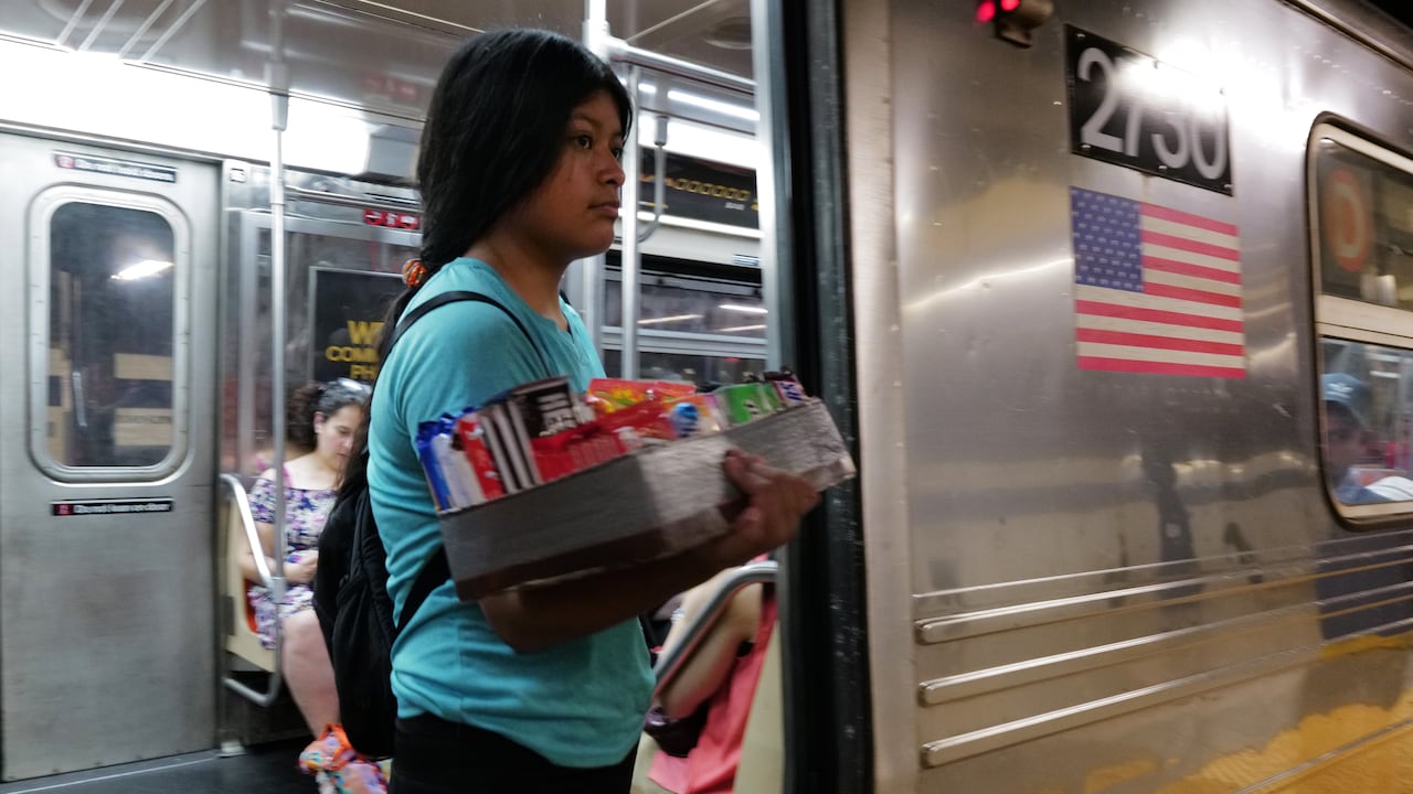 Un adolescente vende dulces y otros artículos en un vagón del metro de la ciudad de Nueva York el 18 de agosto de 2023 en la ciudad de Nueva York. Más de 70.000 solicitantes de asilo han llegado a la ciudad de Nueva York desde el año pasado, según el Ayuntamiento, y muchos se han dedicado a vender artículos en las calles y el metro de la ciudad.