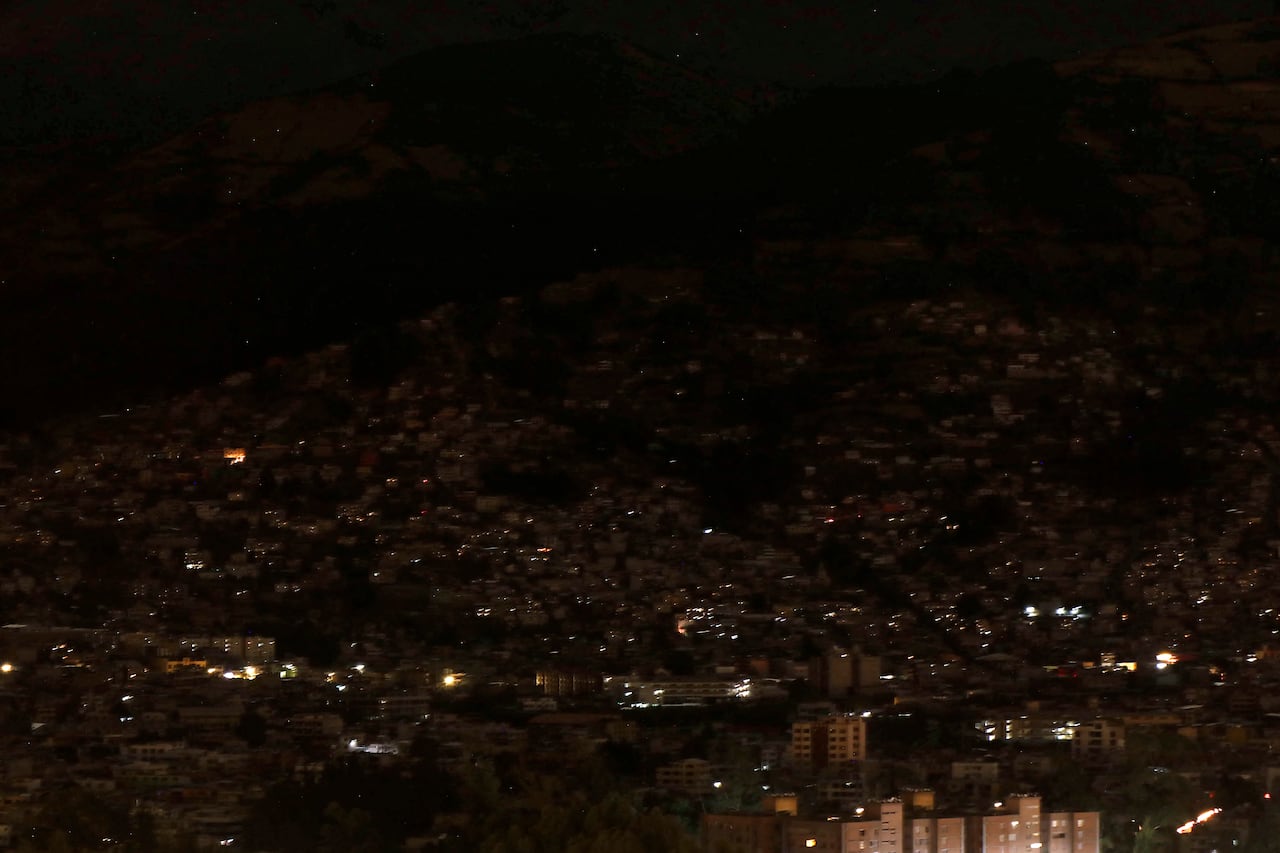 Vista parcial de la ciudad en oscuridad durante un racionamiento nacional programado de electricidad debido al mantenimiento del sistema de transmisión y redes de distribución, en Quito el 18 de septiembre de 2024. Ecuador estará en oscuridad el miércoles por la noche debido a un apagón programado de ocho horas en en medio de una crisis energética resultante de la peor sequía en 60 años. (Foto de Galo Paguay / AFP)