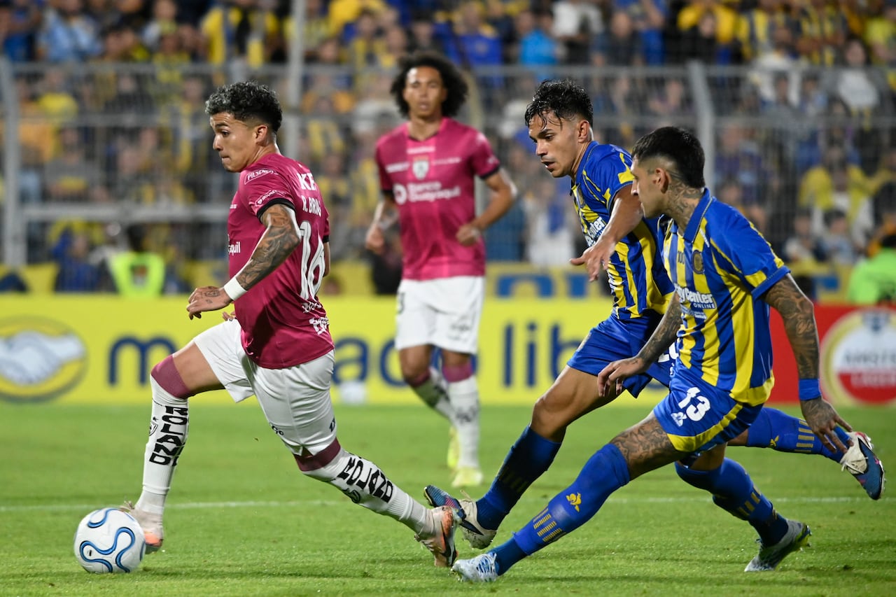 El mediocampista #16 de Independiente del Valle Ronald Briones regatea al mediocampista chileno #20 de Rosario Central Vicente Pizarro y al defensor #13 de Rosario Central Gastón Ávila durante el partido de fútbol de la fase de grupos de la Copa Libertadores entre Rosario Central de Argentina e Independiente del Valle de Ecuador en el estadio Gigante de Arroyito en Rosario, provincia de Santa Fe, Argentina, el 9 de abril de 2026. (Foto de Marcelo Manera / AFP)