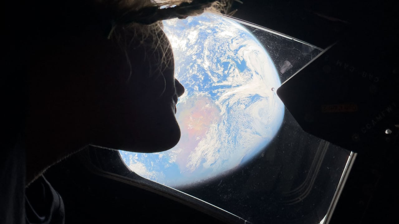 This handout picture by an Artemis II crew member provided by NASA shows Artemis II mission specialist Christina Koch looking back at earth through the window of the Orion spacecraft on April 2, 2026. The four Artemis astronauts have passed the halfway point between Earth and the Moon on the way to their planned lunar flyby, NASA said on April 3. "You are now closer to the moon than you are to us on Earth," mission control told the astronauts at around 11 pm (0400 GMT), according to the space agency's official live broadcast. (Photo by Handout / NASA / AFP) / RESTRICTED TO EDITORIAL USE - MANDATORY CREDIT "AFP PHOTO / NASA" - HANDOUT - NO MARKETING NO ADVERTISING CAMPAIGNS - DISTRIBUTED AS A SERVICE TO CLIENTS